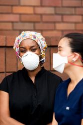 Close up of two nurses talking on break outside together