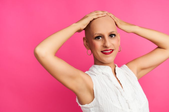 Woman with cancer optimistic after chemotherapy touches her hairless head