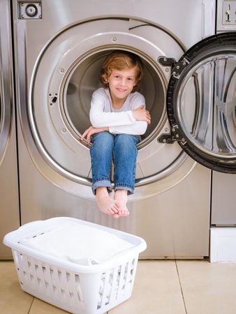 Optimistic boy in drum of washing machine