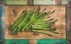 Scattered pieces of  asparagus, on wooden board, horizontal composition