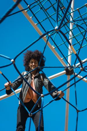 Woman with afro hair climbing by children's attractions.