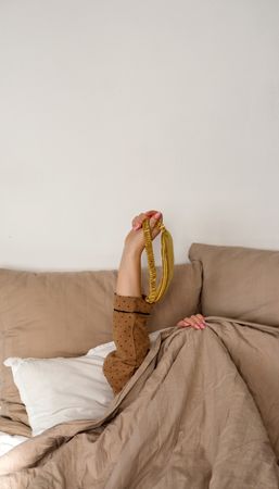 Raised hand holding gold sleep mask
