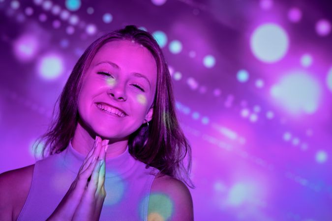 Cheerful young female making wish
