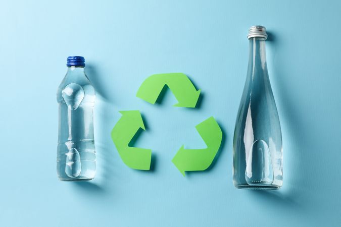 Glass and plastic water bottle with recycling symbol