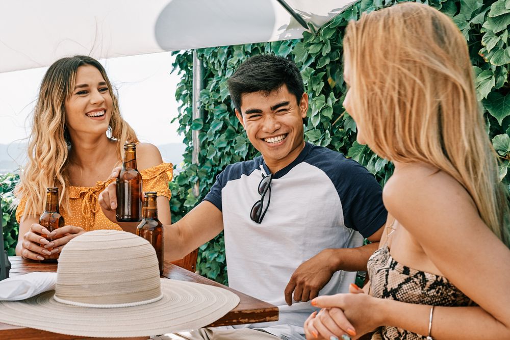 a group of young people cheering with beer in summer