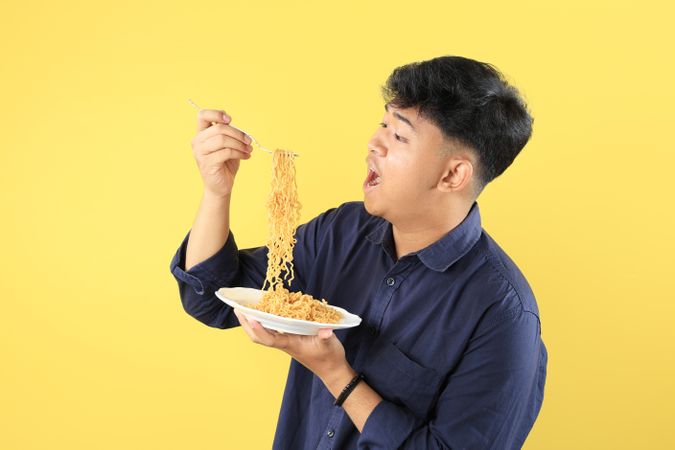 Young Asian Man Enjoy Instant Noodles with Happy Face