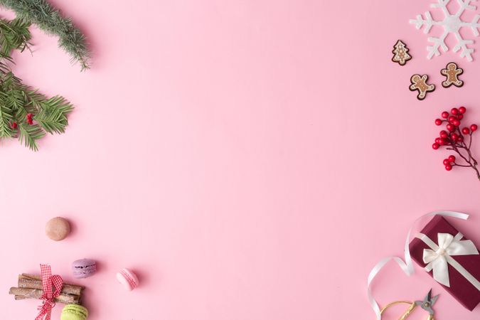 Winter Christmas table layout with presents, decorations, branches on pastel pink background