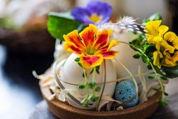 Easter holiday card concept with close up of decorative eggs with colorful flowers