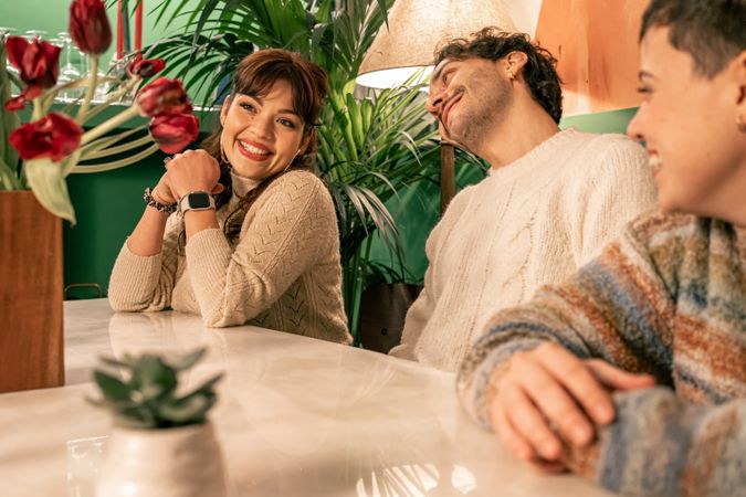 Happy woman in a candid moment, smiling with friends in a cozy bar or at home