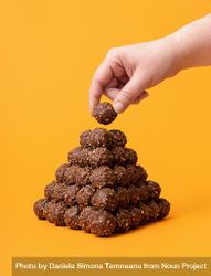 Chocolate candies stacked as a pyramid on an orange background 5nXgAb