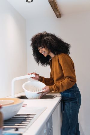 Woman washing chickpeas in sink