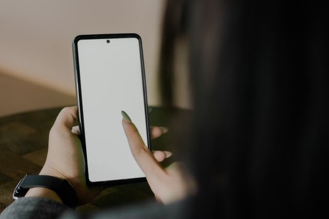 Woman interacting with a smartphone, demonstrating blank screen