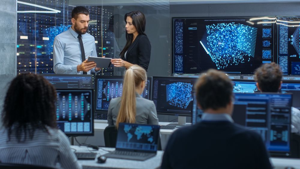 Head of the Department and Project Manager Discuss Work Process Using Data on Tablet Computer.