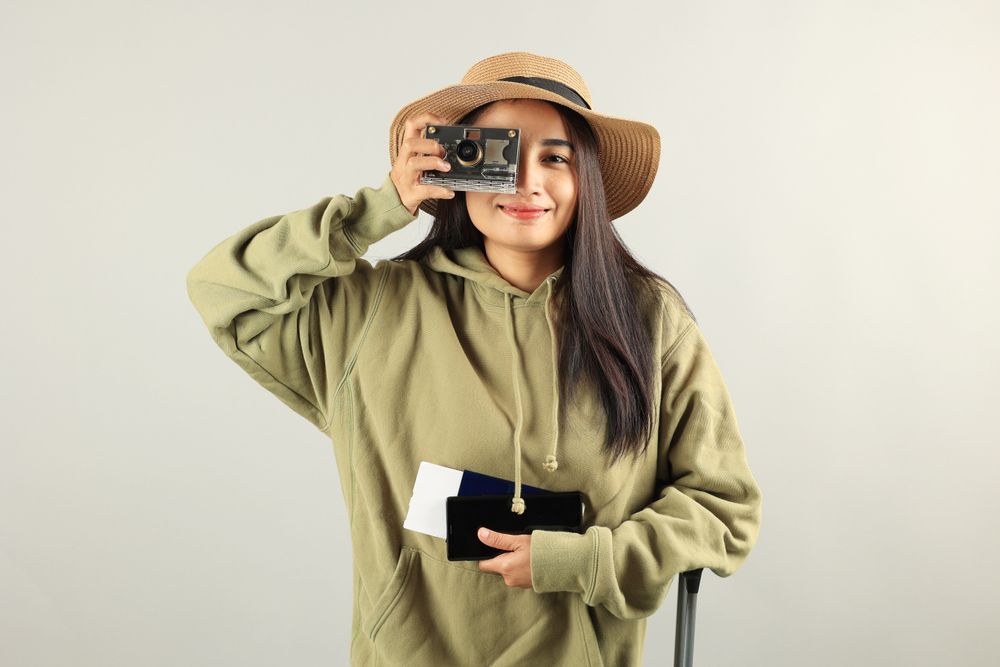 Asian Woman Traveler with Luggage, Camera, Passport, Boarding Pass Ticket,  and  Mobile Phone