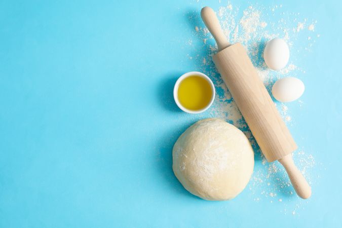 Concept for baking with dough on blue background