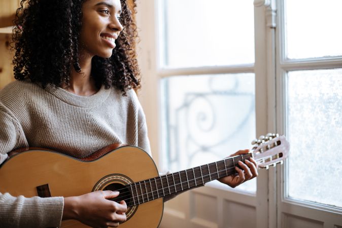 Woman playing guitar in studio