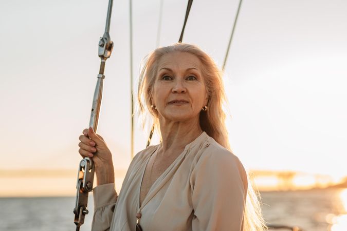 Portrait of elegant older woman on a sailboat at dusk
