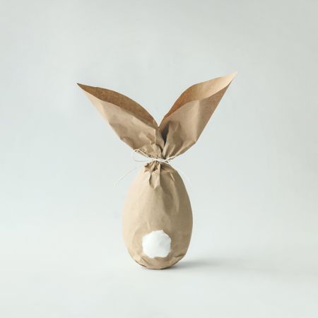 Egg wrapped in brown paper in Easter bunny shape