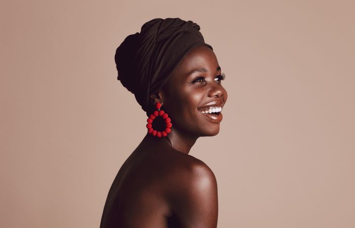 Close up of smiling African woman on beige background