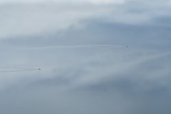 Small speedy aircraft flying in cloudy sky