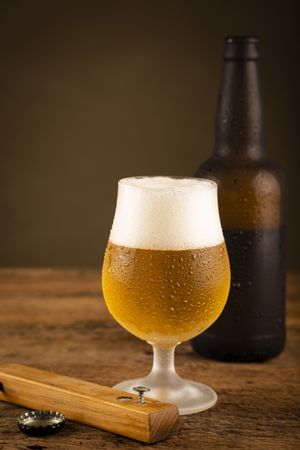 Glass full of cold beer on the wooden table