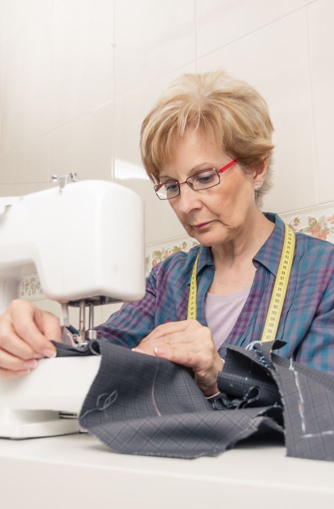 Mature seamstress woman working on sewing machine