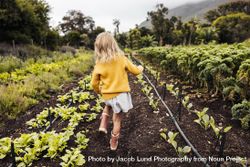 Young blonde girl walking through an organic farm during the day 4dyWnb