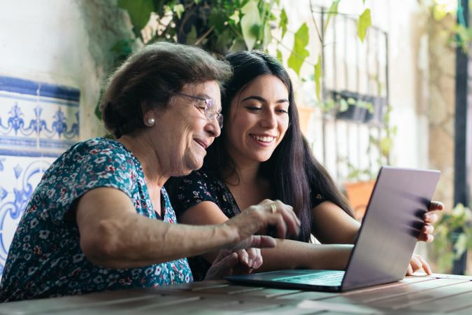 Grandmother and granddaughter making video call with laptop