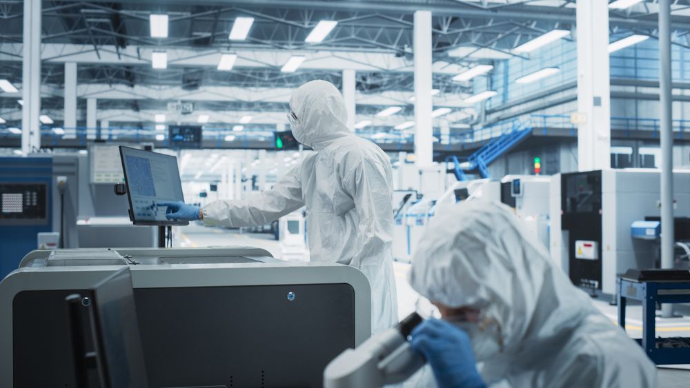 Scientists in hazmat protective suit working in laboratory
