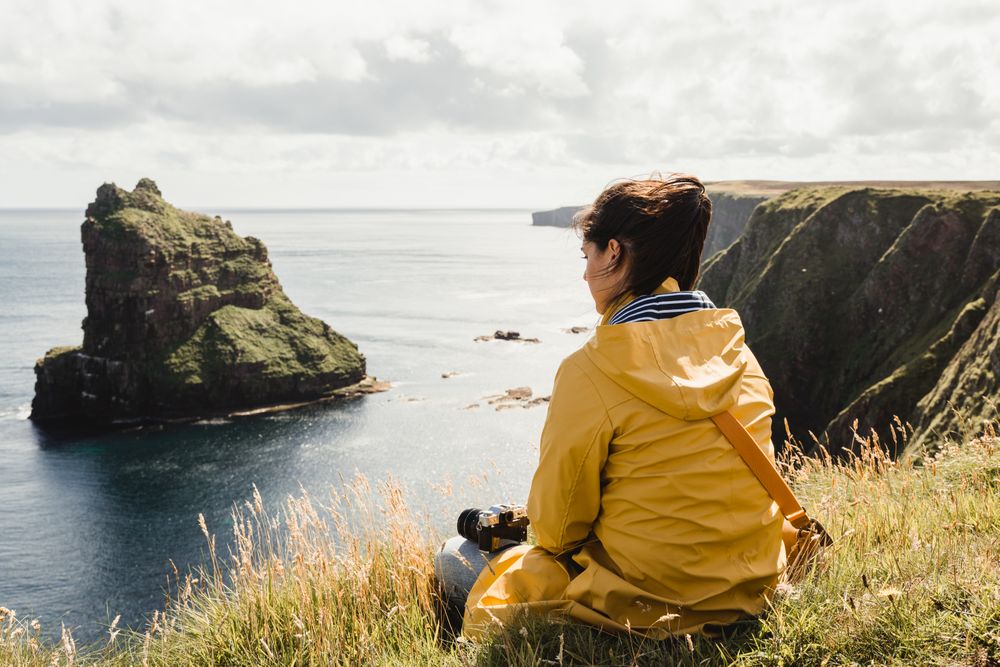Serene tourist enjoying view of tranquil green valley in cloudy weather