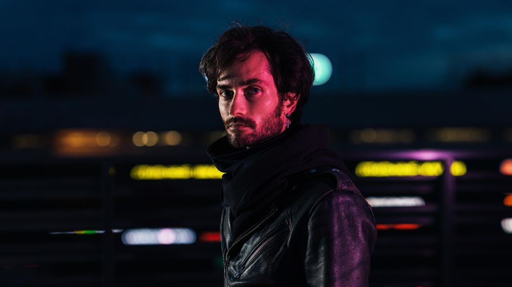 Man in moody red lighting on a rooftop
