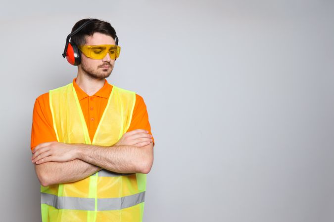 Young man civil engineer in ear protectors and goggles