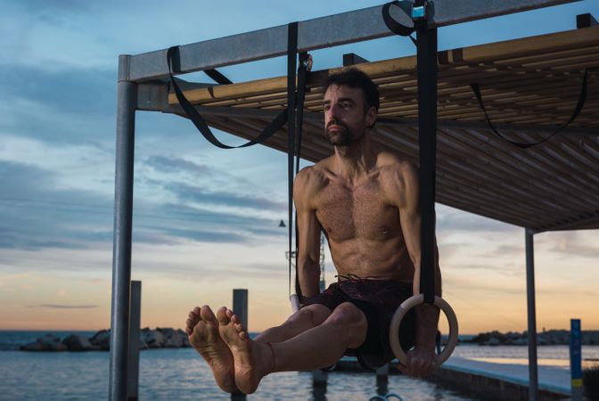 Athletic man balancing on gymnastic rings