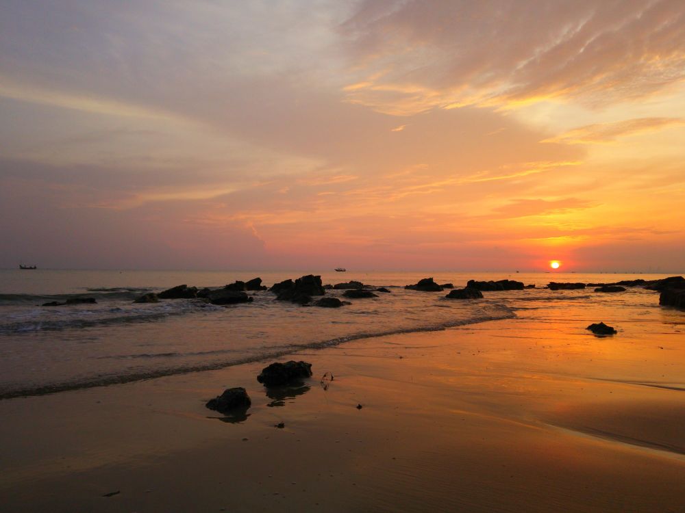 Sea waves crashing on shore during sunset