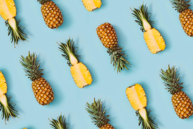 Pineapple in rows on pastel blue background