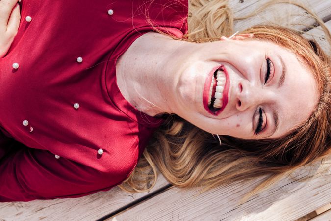 Smiling woman laying down on picnic table