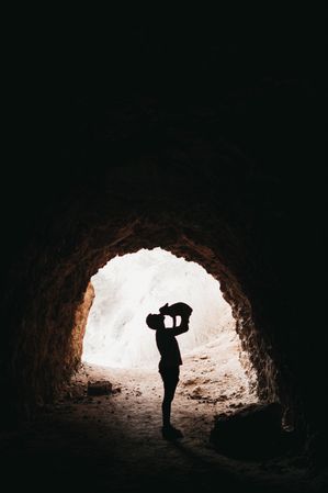 Traveler playing with dog in dark cave