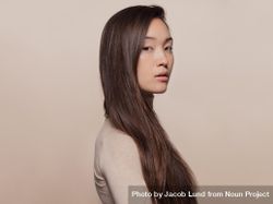 Profile shot of Korean woman with a long straight hair looking at camera 5Xw270