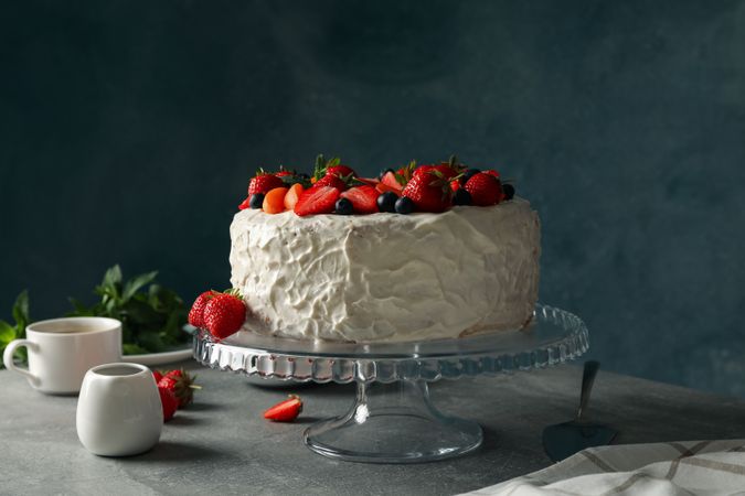 Composition with delicious berry cream cake on gray table. Tasty dessert