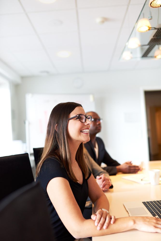 Woman smiling in meeting with colleagues