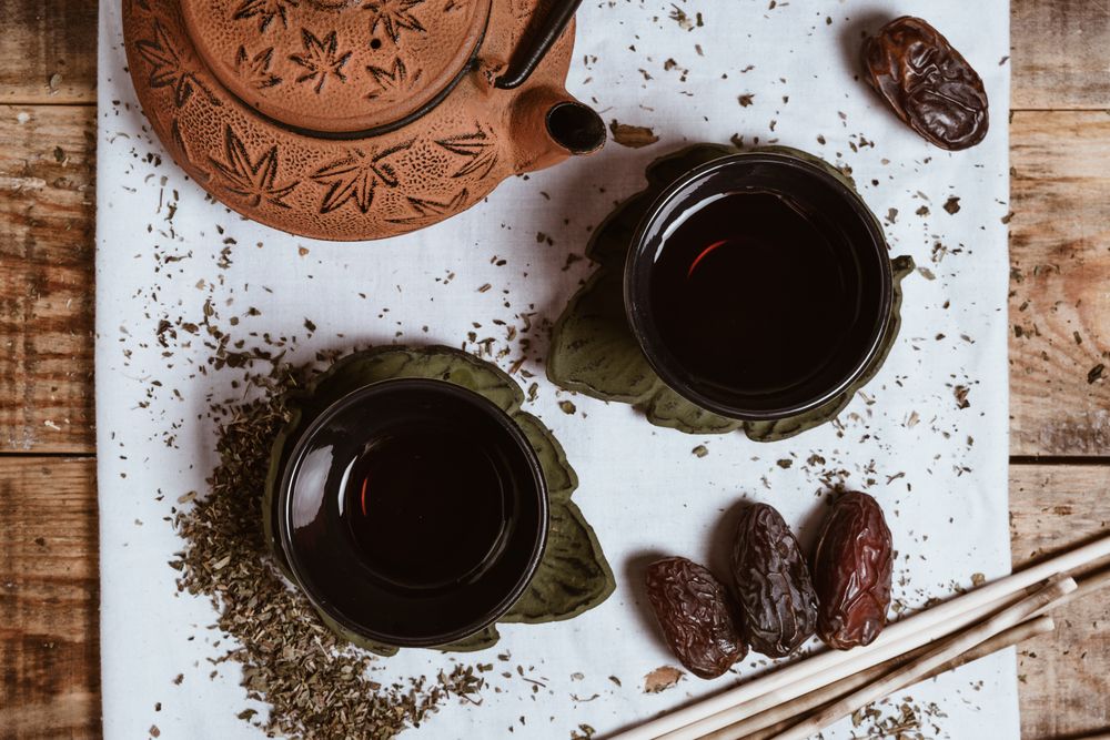 Aromatic tea dates and clay teapot on table