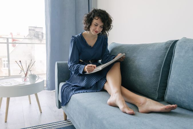 Woman artist drawing at sofa