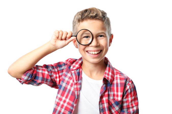 Boy in shirt with magnifier isolated on blank background
