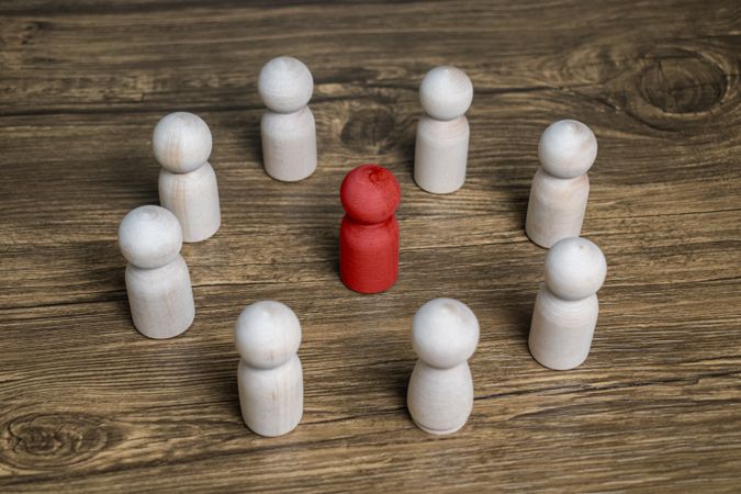 red wooden figure stand to the wooden group crowd. leadership and teamwork concept