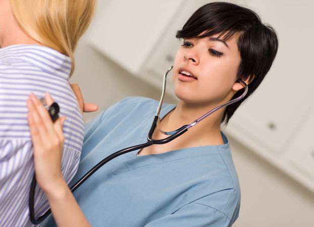 Young Female Doctor Using Stethoscope with Patient
