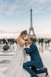 Bridegroom kneeling and kissing hands of bride