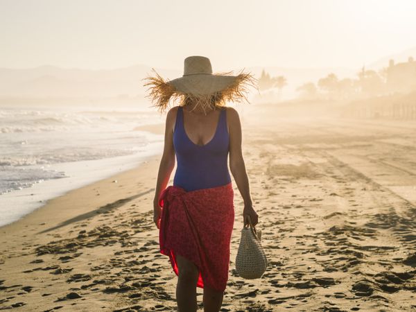 Woman holding walking along seaside