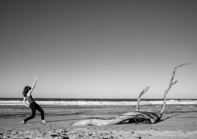 Young woman dancing and posing near water on shore
