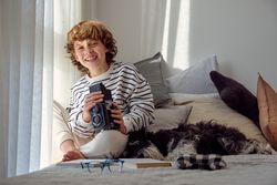 Happy boy with old photo camera and Miniature Schnauzer indoors