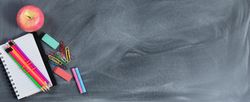 Back to school concept with erased chalkboard and student supplies